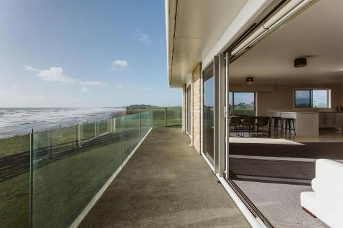 a view of the ocean from the balcony of a house at ABC on Wanaka Bay - beachfront home w. ocean views in New Plymouth