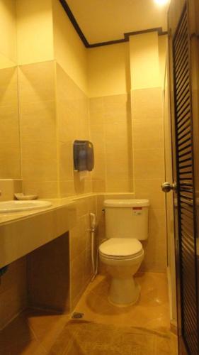 a bathroom with a toilet and a sink at Supak Hotel in Kalasin