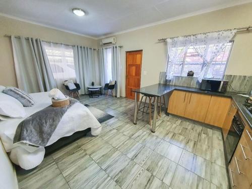a bedroom with a bed and a desk and a kitchen at Hippo's Rest in Ellisras