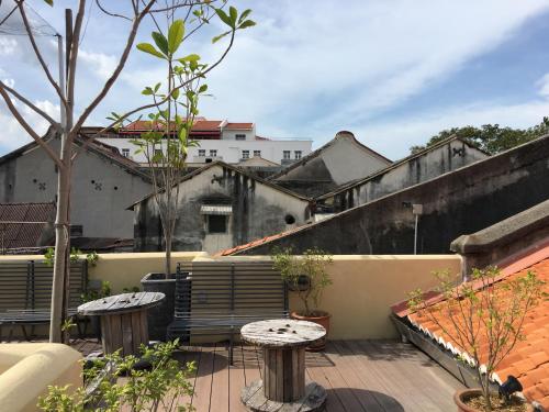 a balcony with two tables and some buildings at Spices Hotel in George Town