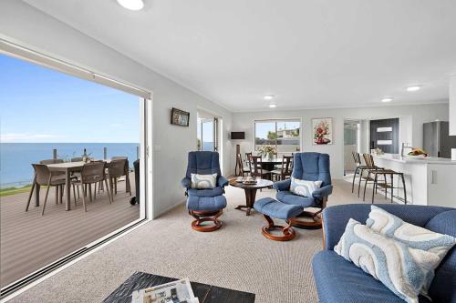 a living room with a view of the ocean at Beachfront Breeze - sea views for days in New Plymouth