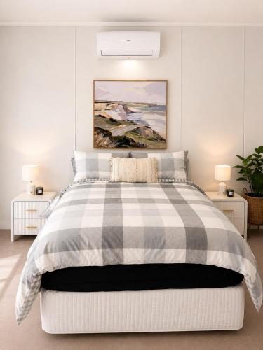 a bedroom with a bed with a checkered blanket at Gem on Matrix - Hidden Retreat with Deck in Lightning Ridge