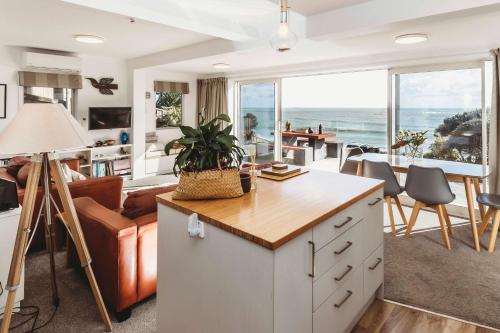 a kitchen and living room with a view of the ocean at Te Moana Waterfront - beachside accommodation in New Plymouth