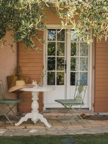 a patio with a table and chairs in front of a door at Exceptional Apartment In Cannes' Countryside in Spéracèdes