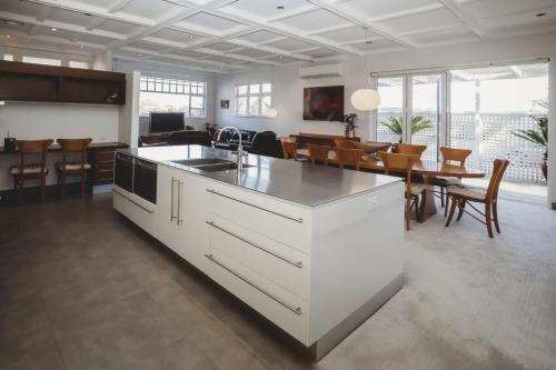 a kitchen and dining room with white cabinets and a table at The Front Office - charming 3BR heritage home in New Plymouth