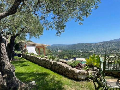 a garden with a stone wall and a bench at Exceptional Apartment In Cannes' Countryside in Spéracèdes