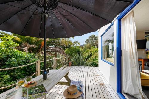 a patio with an umbrella on a deck at Butlers Studio Two in Oakura