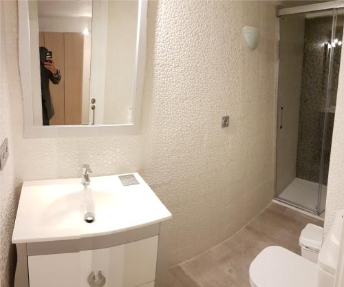 a man taking a picture of a bathroom with a sink and toilet at Gafner 2 in Alicante