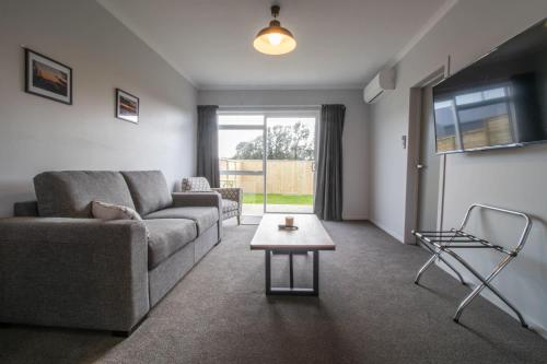 a living room with a couch and a table at The Window Seat - pet-friendly 1BR apartment in Waitara