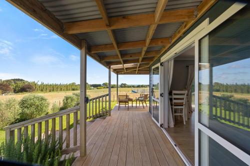 a porch of a home with a wooden deck at Weld Cottage - Sustainable lifestyle property in New Plymouth