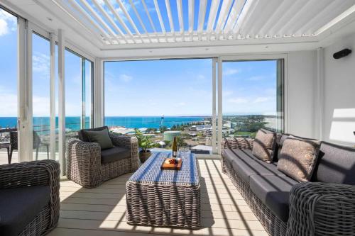 a living room with a couch and chairs and windows at Seaview on Findlay in New Plymouth