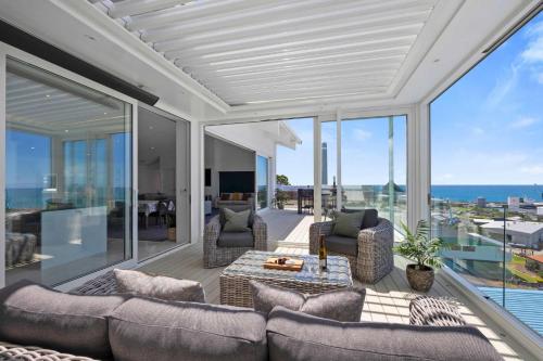 a living room with a couch and chairs on a balcony at Seaview on Findlay in New Plymouth