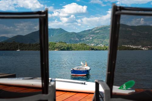 a boat on a lake with mountains in the background at Dubravcevic Residence in Tivat