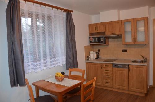 a small kitchen with a table and a table and a window at Haus Tolštejn in Jiřetín pod Jedlovou