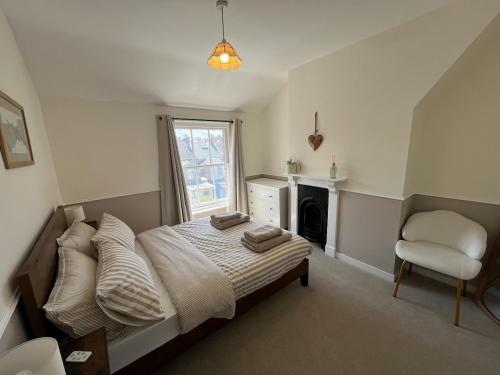 a bedroom with a bed with a chair and a window at Number 29 in Melcombe Regis