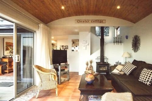 a living room with a couch and a tv at Chester Cottage Beachfront - direct ocean access in Oakura