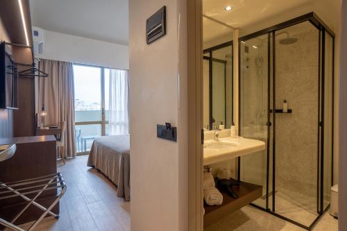a hotel room with a bathroom with a sink and a shower at Olympic Hotel in Heraklio