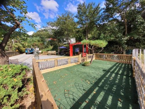 a yard with a wooden fence and a yard with a yard at Gapyeong Petmily Dog Pension in Gapyeong