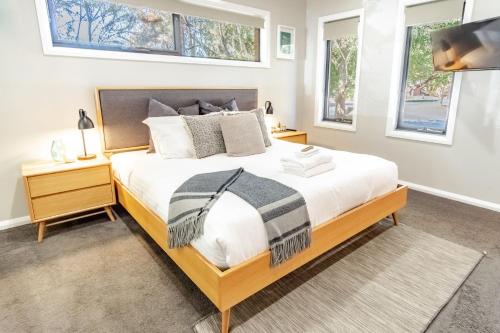 a bedroom with a large bed and two windows at Amaroo in Bright