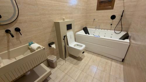 a bathroom with a toilet and a bath tub at Room 7 in Nizwa