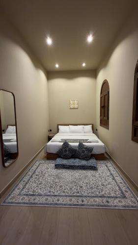 a bedroom with a bed and a large rug at Room 7 in Nizwa