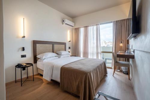 a hotel room with a bed and a balcony at Olympic Hotel in Heraklio