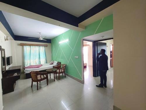 a man standing in a room with a dining room at Hotel World Beach Resort in Cox's Bazar