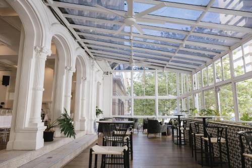 a large room with tables and chairs and windows at Ambassadors Hotel in Adelaide