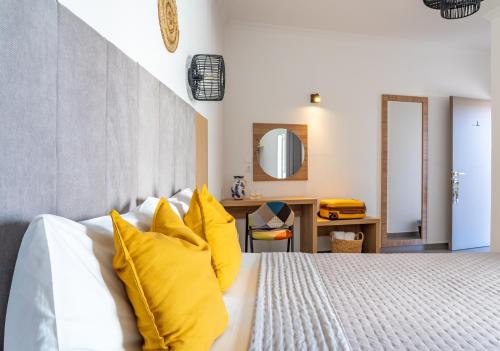 a bedroom with a bed with yellow pillows at Cactus in Skiathos