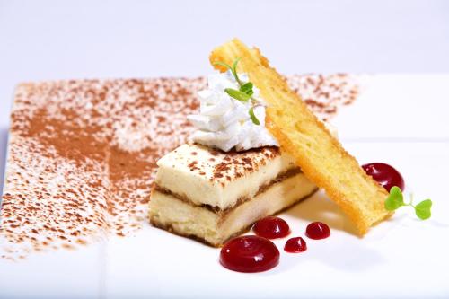 a piece of cake with whipped cream and cherries on a plate at Warwick Paradise Island Bahamas - All Inclusive - Adults Only in Nassau