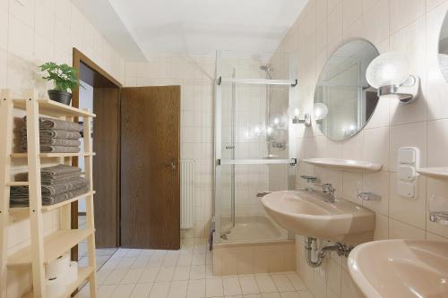 a white bathroom with a sink and a shower at Apartment am Bischofsberg in Großheubach