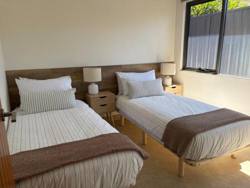 a bedroom with two beds and a window at The Mandurah Hideaway in Mandurah