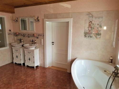 a bathroom with two sinks and a bath tub at Fewo-Auf-der-Muehlwiese-fuer-4-10-Personen in Großschönau
