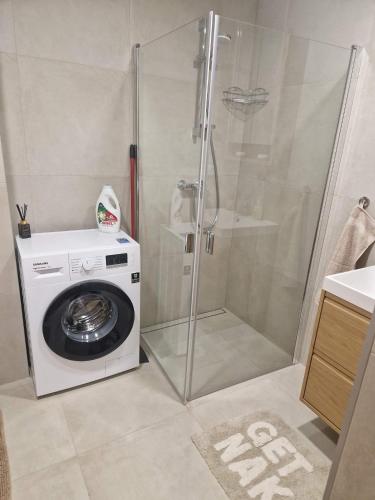 a washing machine and a shower in a bathroom at Oja 69-4 Apartment in Pärnu