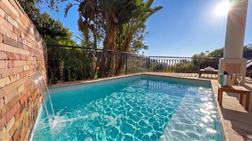 a swimming pool with a water fountain at Villa Seaview, Private Oceanfront Villa, Heated Pool & Whale Watching Views, Knysna Heads in Knysna