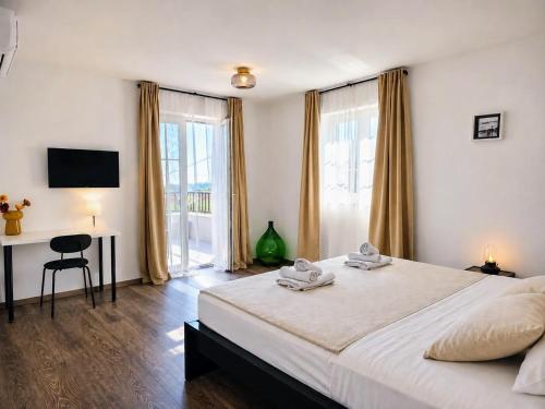 a bedroom with a bed and a desk and a window at Villa Gaudeo with pool and EV station in Nova Vas