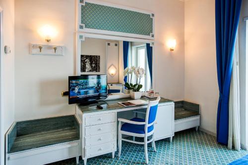 a room with a desk with a computer and a mirror at Grand Hotel Riviera in Sorrento