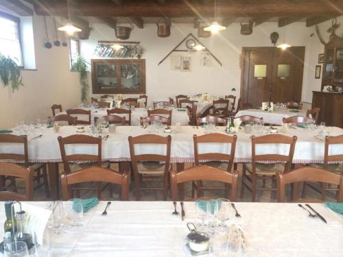 ein großes Esszimmer mit weißen Tischen und Stühlen in der Unterkunft Agriturismo Paradiso in Sarego