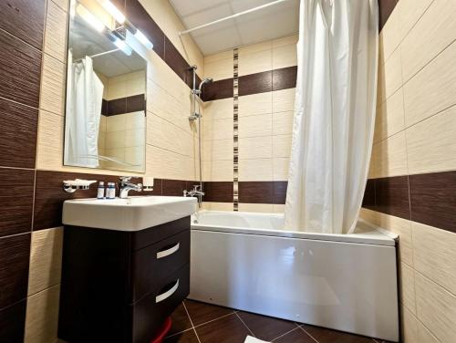 a bathroom with a sink and a tub and a shower at Europroperties Golden Line in Golden Sands