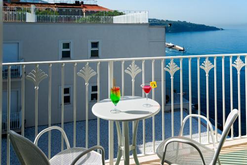 a balcony with a table with two drinks on it at Grand Hotel Riviera in Sorrento