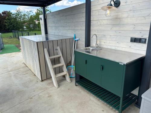 a kitchen with a sink and a ladder on a patio at ChillHouse 2 in Békésszentandrás