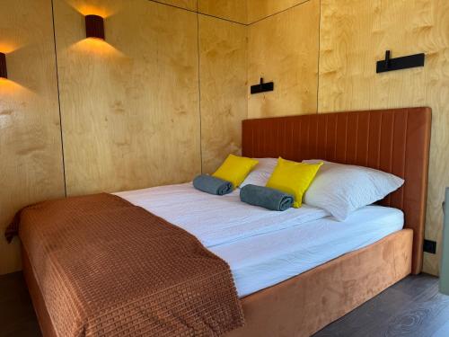 a bed with two yellow pillows on top of it at ChillHouse 2 in Békésszentandrás
