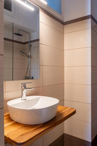 a bathroom with a white sink on a wooden counter at Central Guest House Skiathos in Skiathos