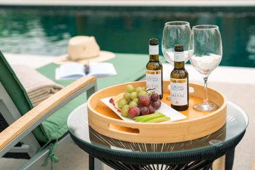 a tray of wine bottles and wine glasses on a table at Oria Retreat in Danilovgrad