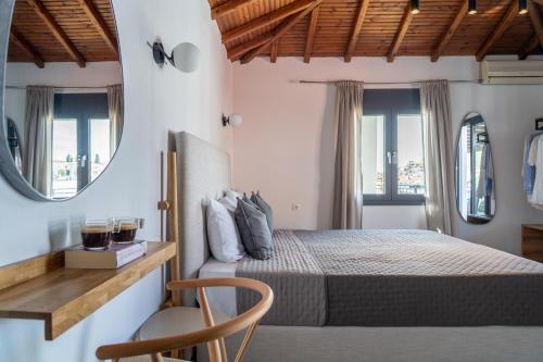 a bedroom with a bed and a chair and windows at Central Guest House Skiathos in Skiathos