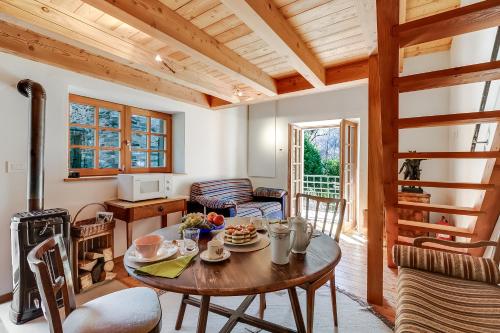 a kitchen and living room with a wooden table at Mille Colline la Casa 1 with Shared Pool - Happy Rentals in Pianezzo