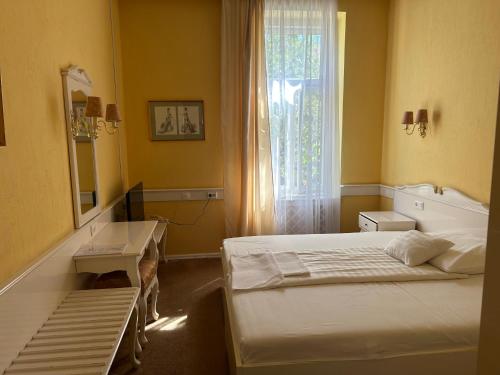 a bedroom with two beds and a window at Fiume Hotel in Békéscsaba