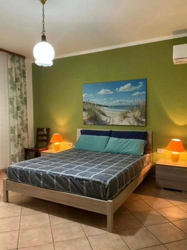 a bedroom with a bed with a painting on the wall at Le case di Helga in Budoni
