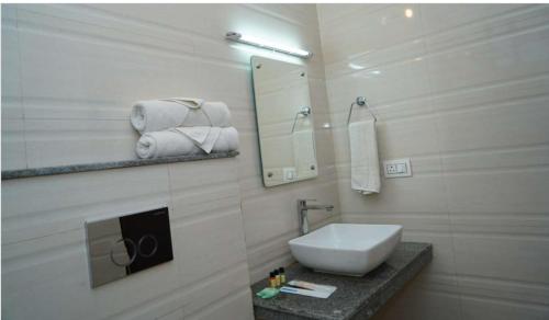 a bathroom with a sink and a mirror and towels at Blue River Resort in Rāmnagar