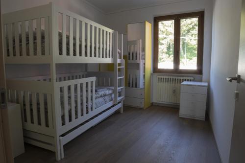 a room with white bunk beds and a window at Murazzanino in Murazzano